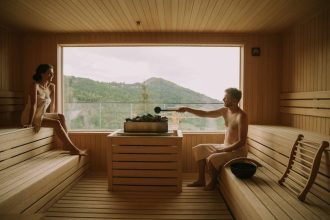 jeune couple se détendant dans un sauna en bois chaleureux