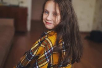 petite fille avec un plaid à la maison