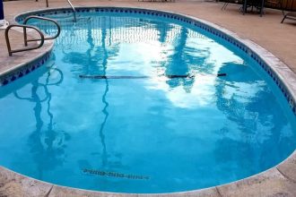 piscine coque polyester installée dans un jardin moderne